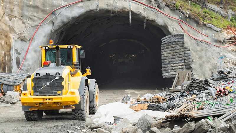 A Heavy Duty Loader Stands Ready At The Entrance Of A Tunnel Construction Site